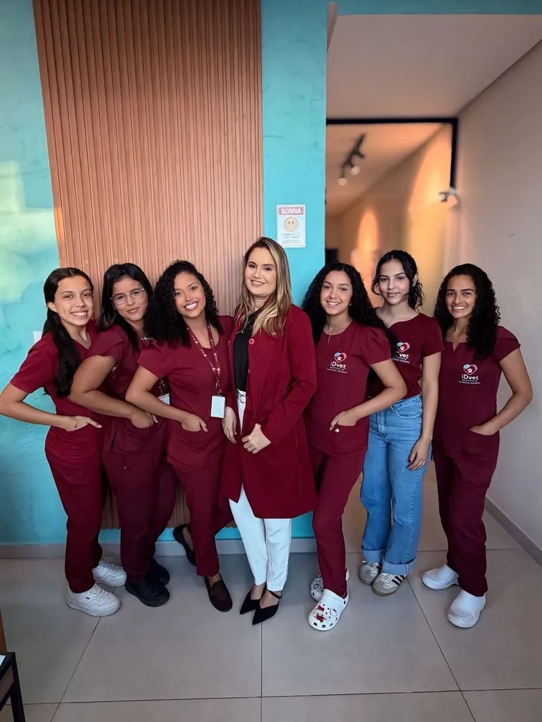 Equipe do iDvet reunida na clínica, com uniformes vinho